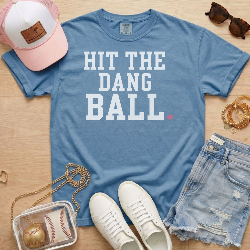 Blue Jean Comfort Colors Hit The Dang Ball baseball game day shirt with white varsity lettering, styled as a casual baseball
mom outfit.