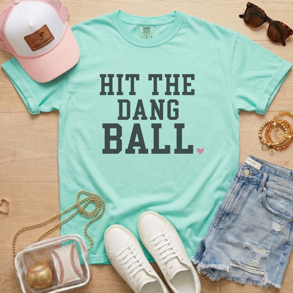 Chalky Mint Hit The Dang Ball baseball mom tee on Comfort Colors shirt styled with baseball accessories, denim shorts, and white sneakers.