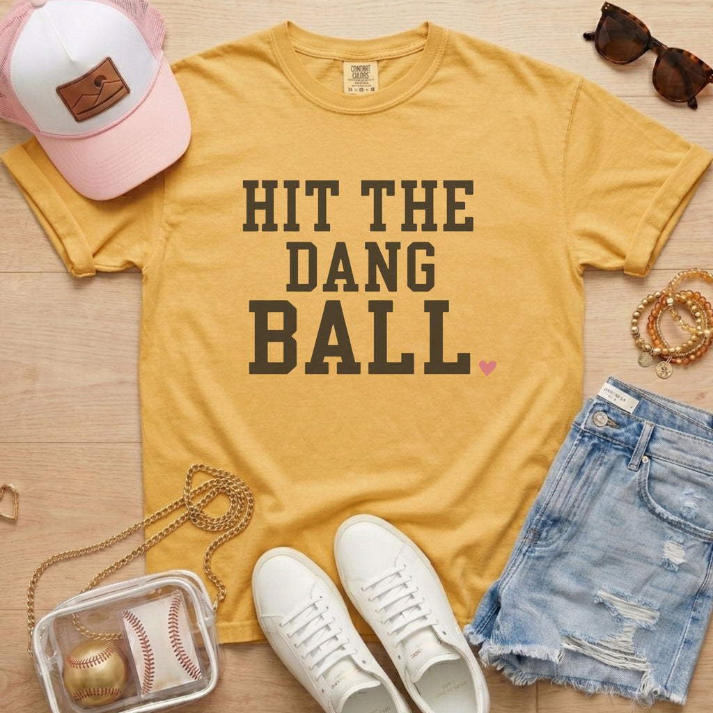 Mustard Comfort Colors Hit The Dang Ball shirt styled as a baseball bleacher outfit with casual game day accessories.
