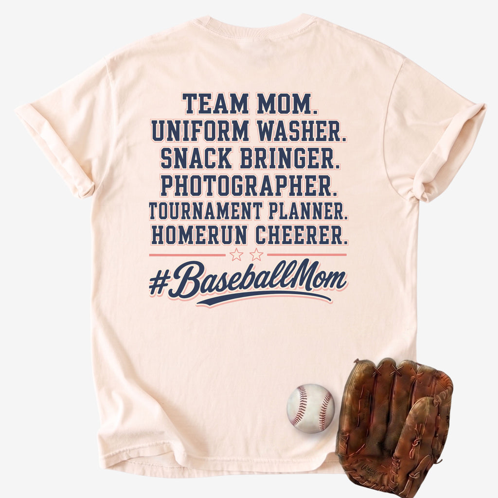 Beige t-shirt with '#BaseballMom' text and baseball-related roles, displayed with a baseball and glove on a light gray background.