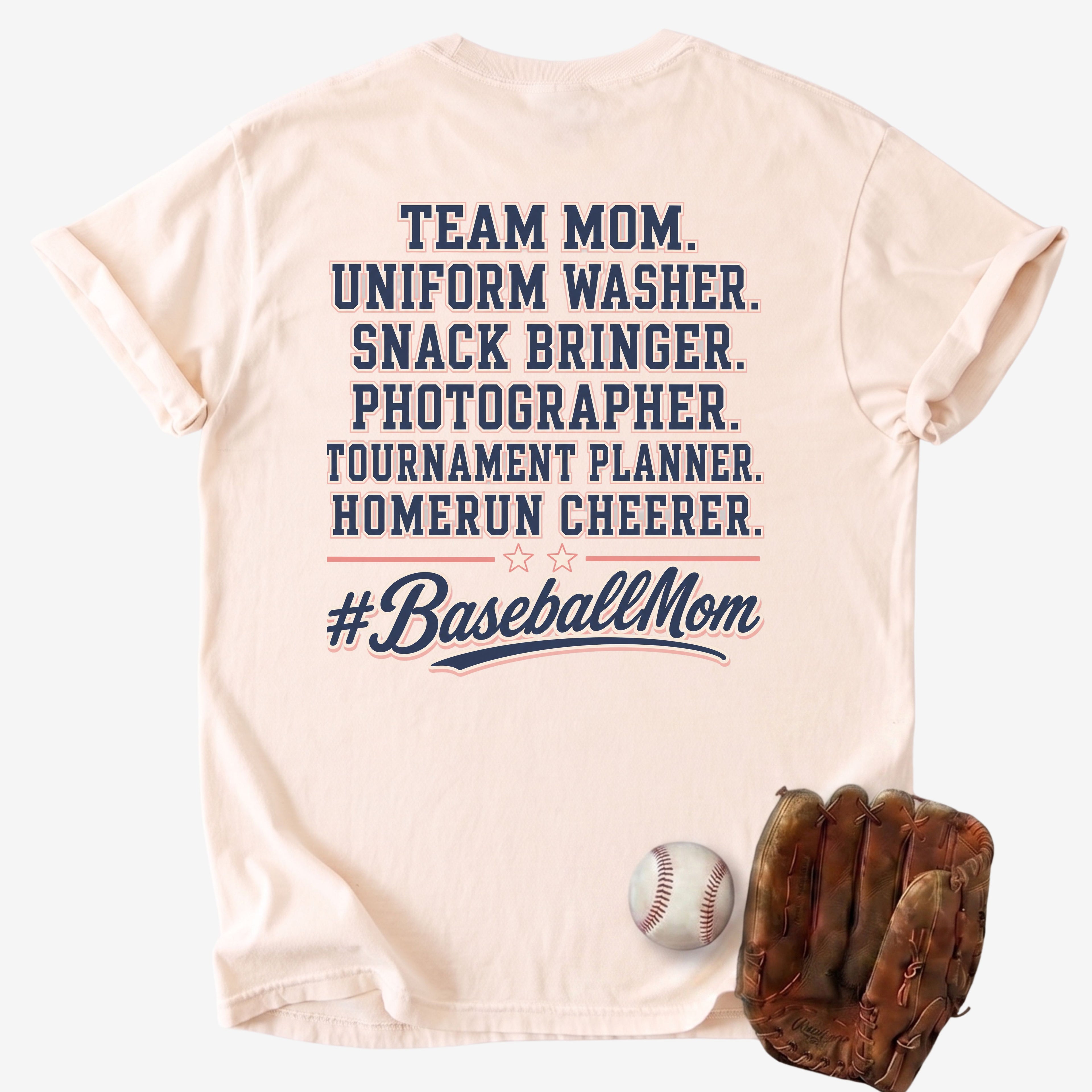 Beige t-shirt with '#BaseballMom' text and baseball-related roles, displayed with a baseball and glove on a light gray background.