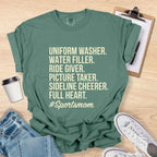 Green t-shirt with '#Sportsmom' text on a wooden surface with accessories.