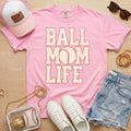 pink baseball mom life shirt with vintage baseball design styled with hat and jewelry