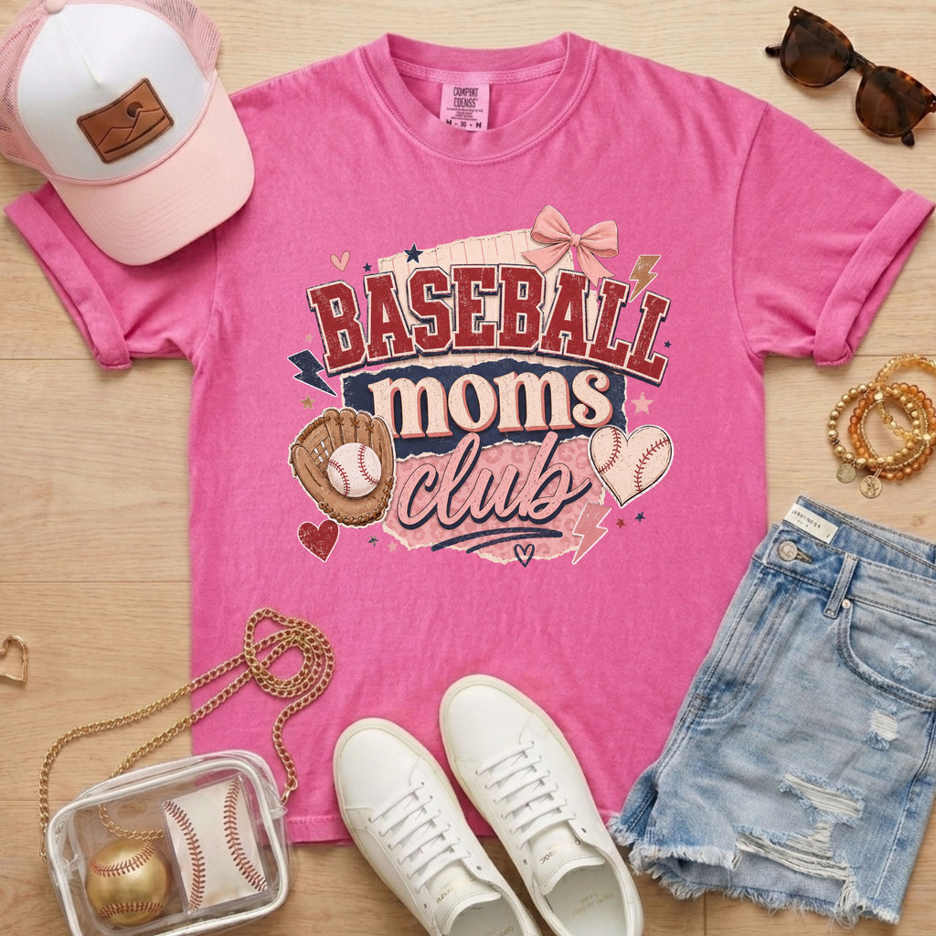 Baseball Moms Club Comfort Colors tee in crunchberry flat lay with trucker hat, denim shorts, white sneakers, and baseball.
