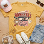 Baseball Moms Club Comfort Colors tee in mustard flat lay with trucker hat, denim shorts, white sneakers, and baseball.