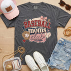 Baseball Moms Club Comfort Colors tee in pepper charcoal flat lay with trucker hat, denim shorts, white sneakers, and baseball.