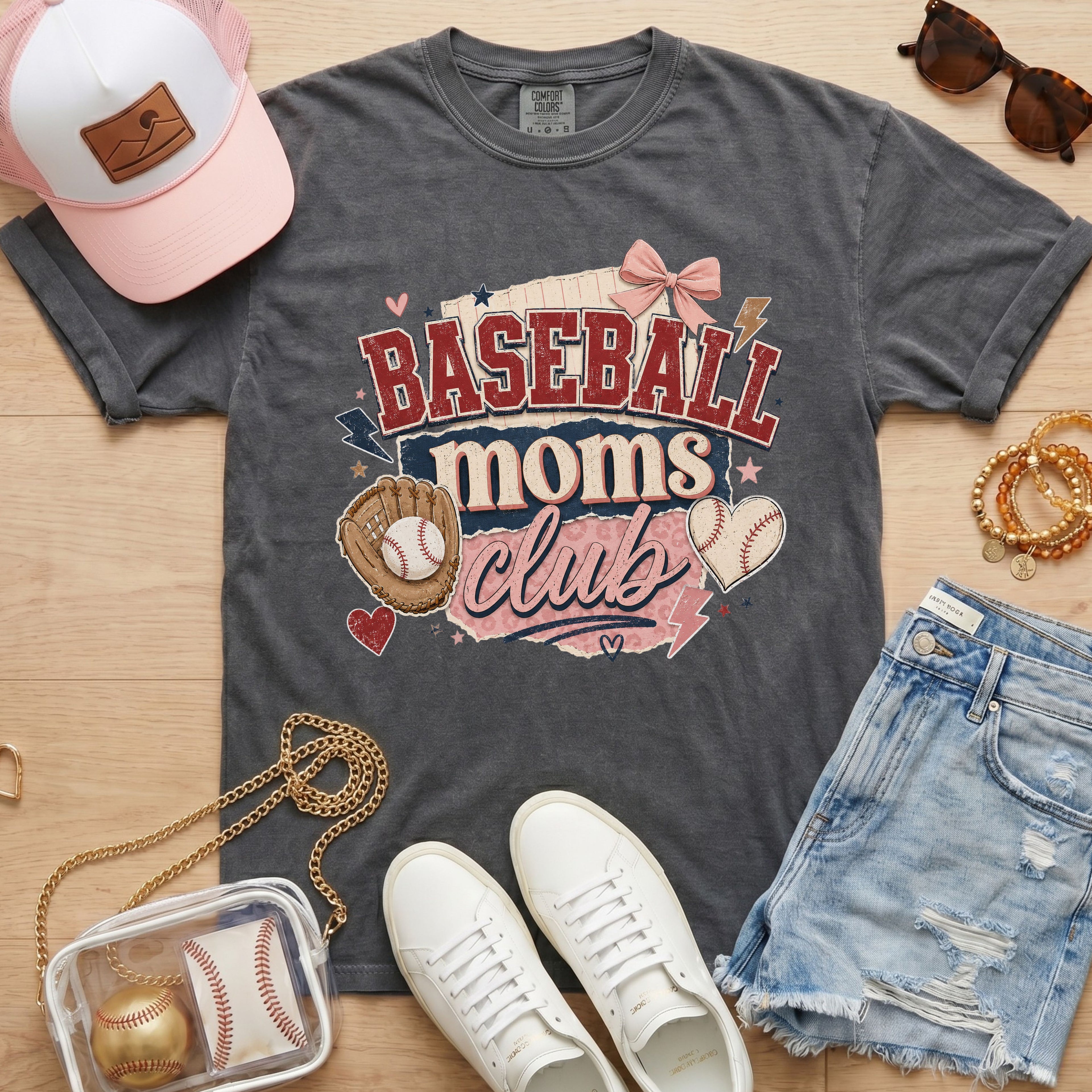 Baseball Moms Club Comfort Colors tee in pepper charcoal flat lay with trucker hat, denim shorts, white sneakers, and baseball.