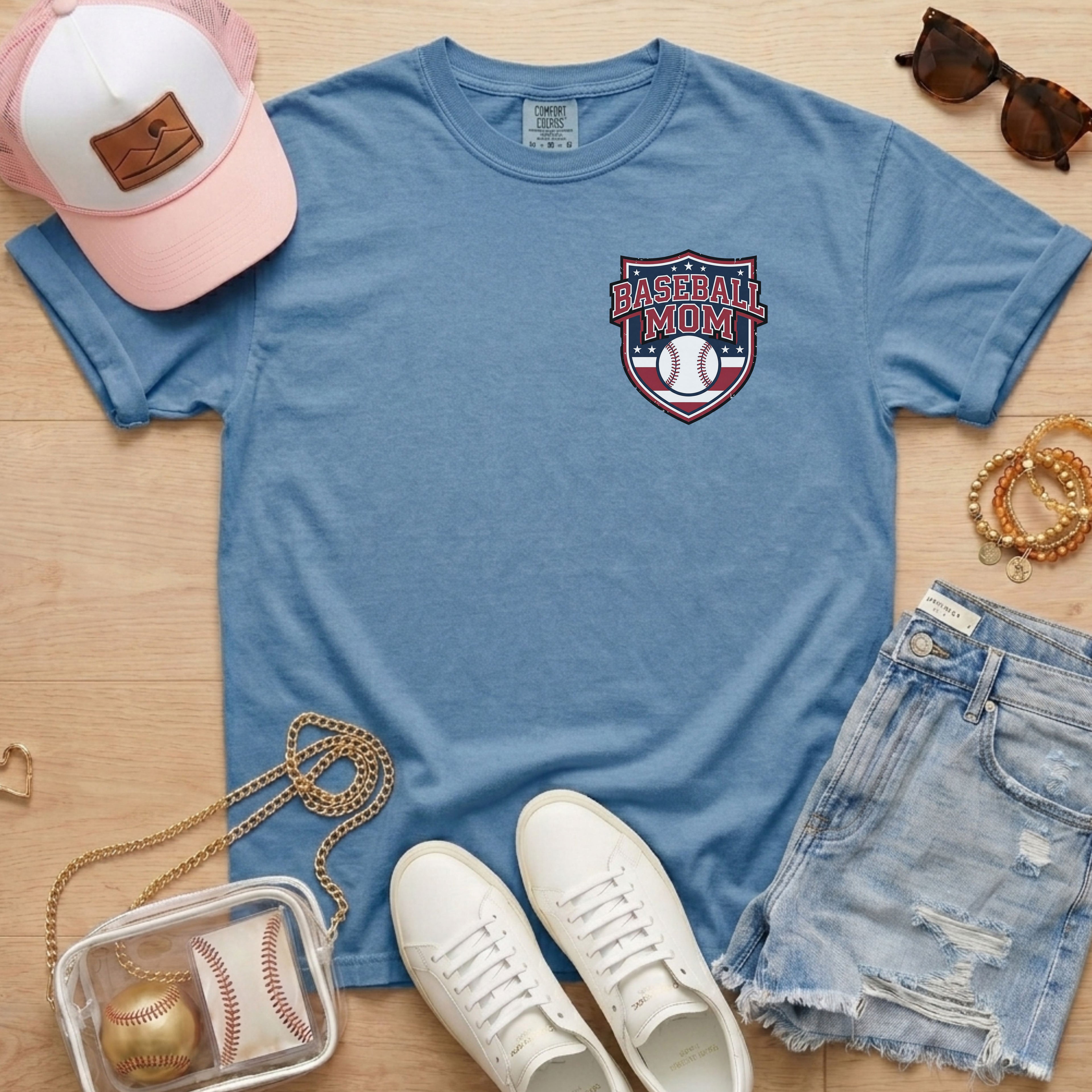 Blue Comfort Colors 1717 t-shirt with a red and blue Baseball Mom crest design on the chest for sports moms