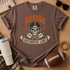 Defensive line football mom graphic T-shirt in dark brown, Comfort Colors Espresso, styled in a football game day flat lay.