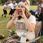 Football mama shirt styled on a football sideline with a game day mom cheering from a chair.