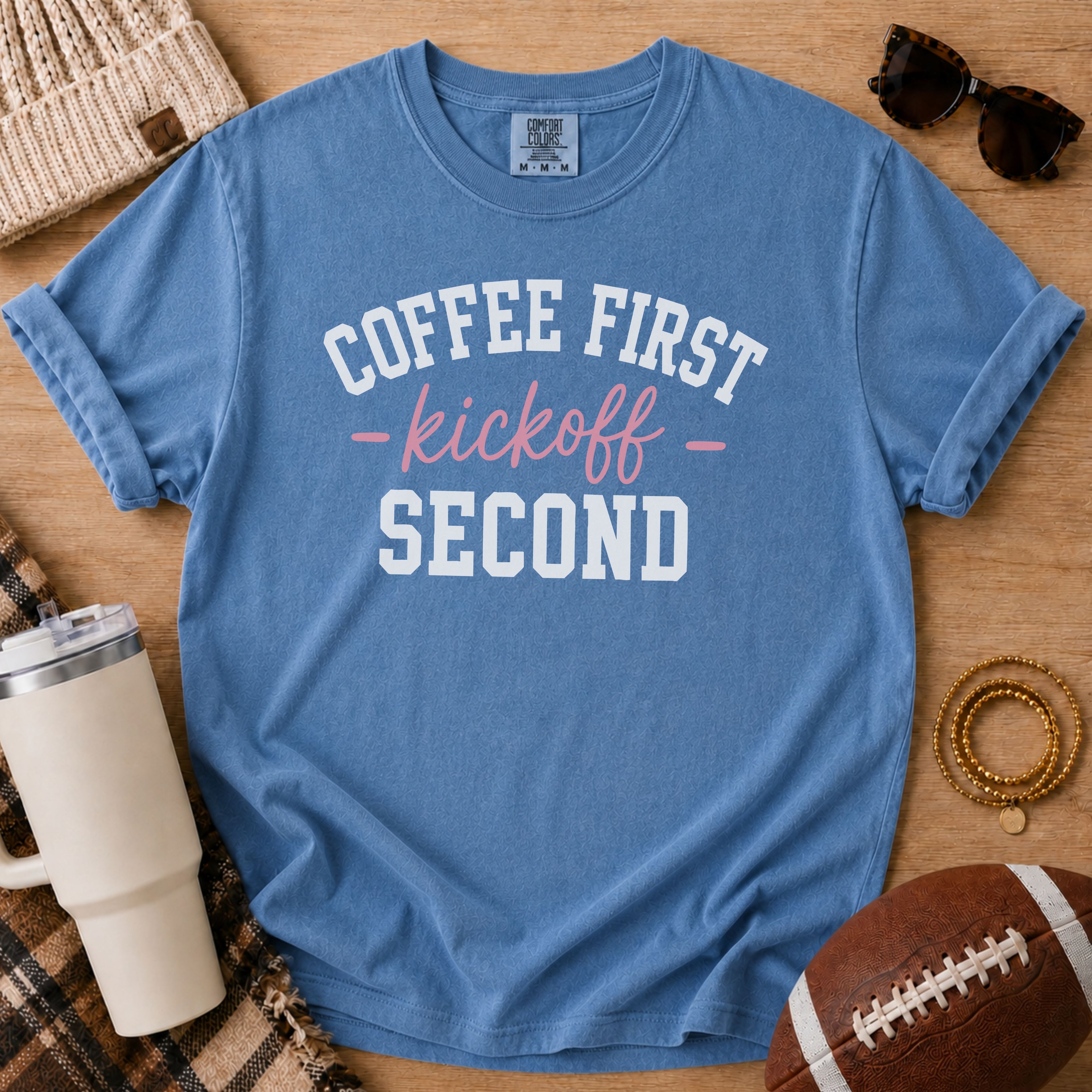 Blue Jean Comfort Colors football mom shirt with Coffee First Kickoff Second design and football prop.