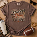 Espresso Comfort Colors football mom shirt with muddy football cleats design and football props.