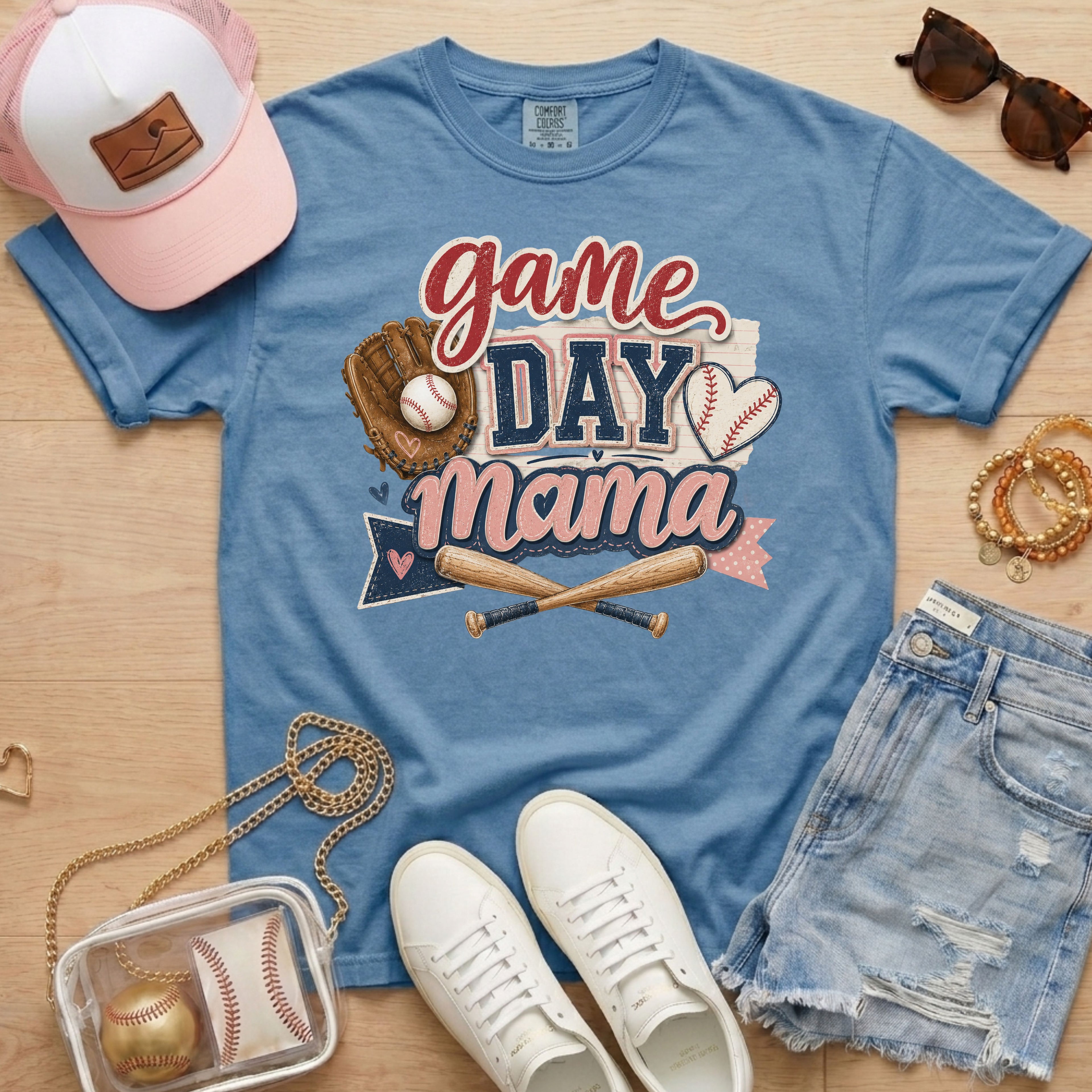 Game Day Mama baseball mom Comfort Colors tee in blue jean flat lay with trucker hat, denim shorts, white sneakers, and baseball.