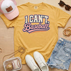 I CAN'T. Baseball. baseball mom Comfort Colors mustard tee in a flat lay with hat, sneakers, denim shorts, and baseball bag.
