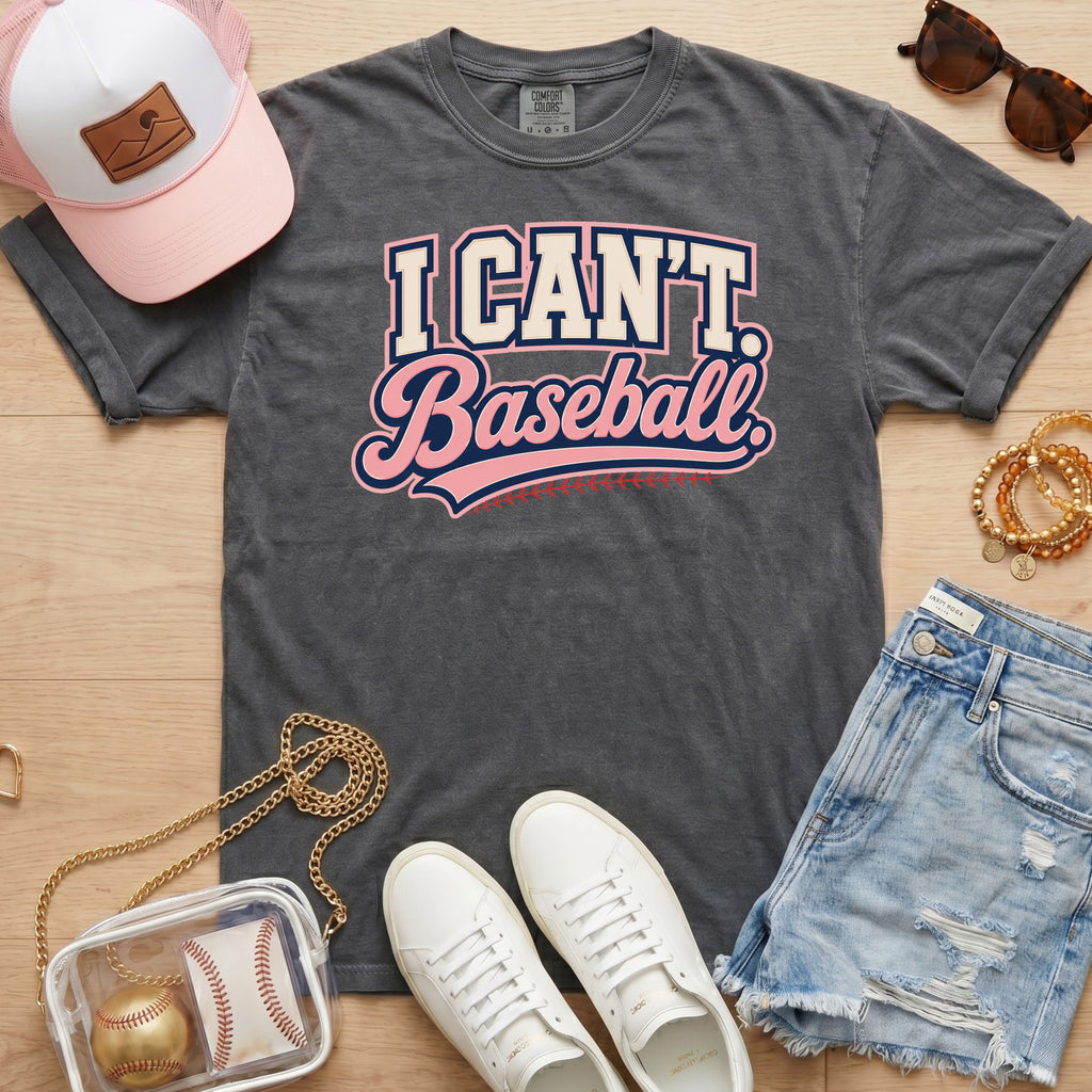 I CAN'T. Baseball. baseball mom Comfort Colors pepper tee in a flat lay with pink hat, sneakers, denim shorts, and baseball bag.