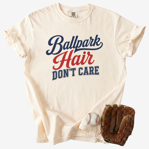 Ivory Comfort Colors Ballpark Hair Don’t Care funny baseball mom shirt displayed with a baseball and glove for a sporty game day product photo.