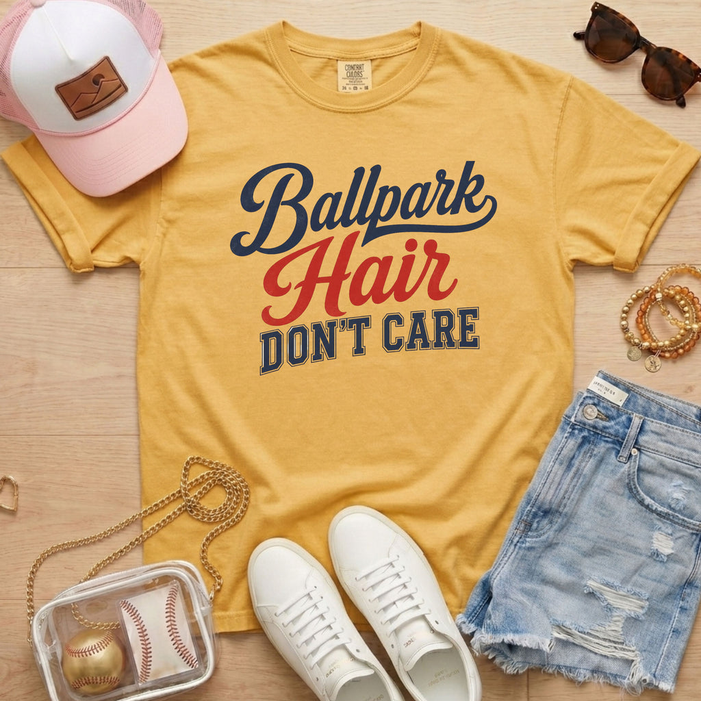Mustard Ballpark Hair Don’t Care funny baseball mom shirt styled with denim shorts, sneakers, clear baseball bag, and bleacher-ready accessories.
