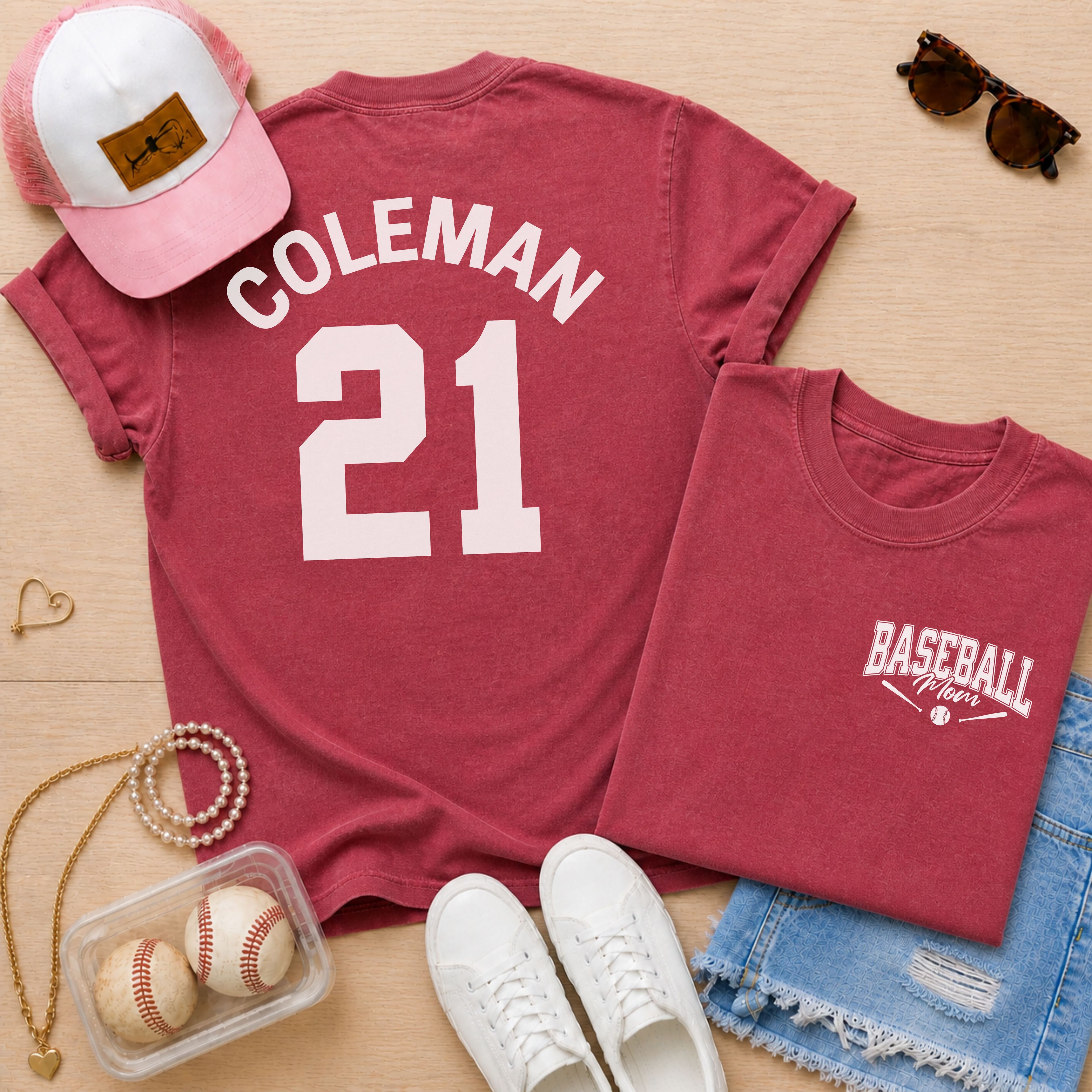 Red t-shirt with 'COLEMAN 21' and 'BASEBALL Mom' text, pink cap, white sneakers, and baseballs on a wooden surface.