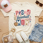 Proud baseball mom Comfort Colors ivory game day tee flat lay with hat sunglasses and denim shorts