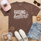 Raising Ballers baseball mom Comfort Colors espresso game day tee styled with hat, denim shorts, and baseball accessories