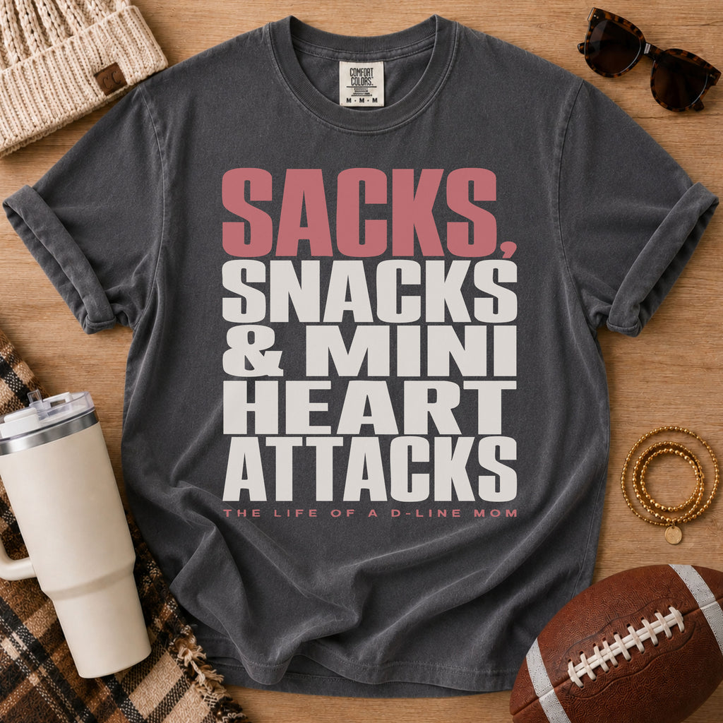 Football lineman mom graphic T-shirt in charcoal gray, Comfort Colors Pepper, styled in a game day flat lay with the D-line mom slogan.