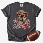 Football mom graphic T-shirt in charcoal gray, Comfort Colors Pepper, featuring a leopard in sunglasses holding a football with jeweled “Sideline Chic” lettering.