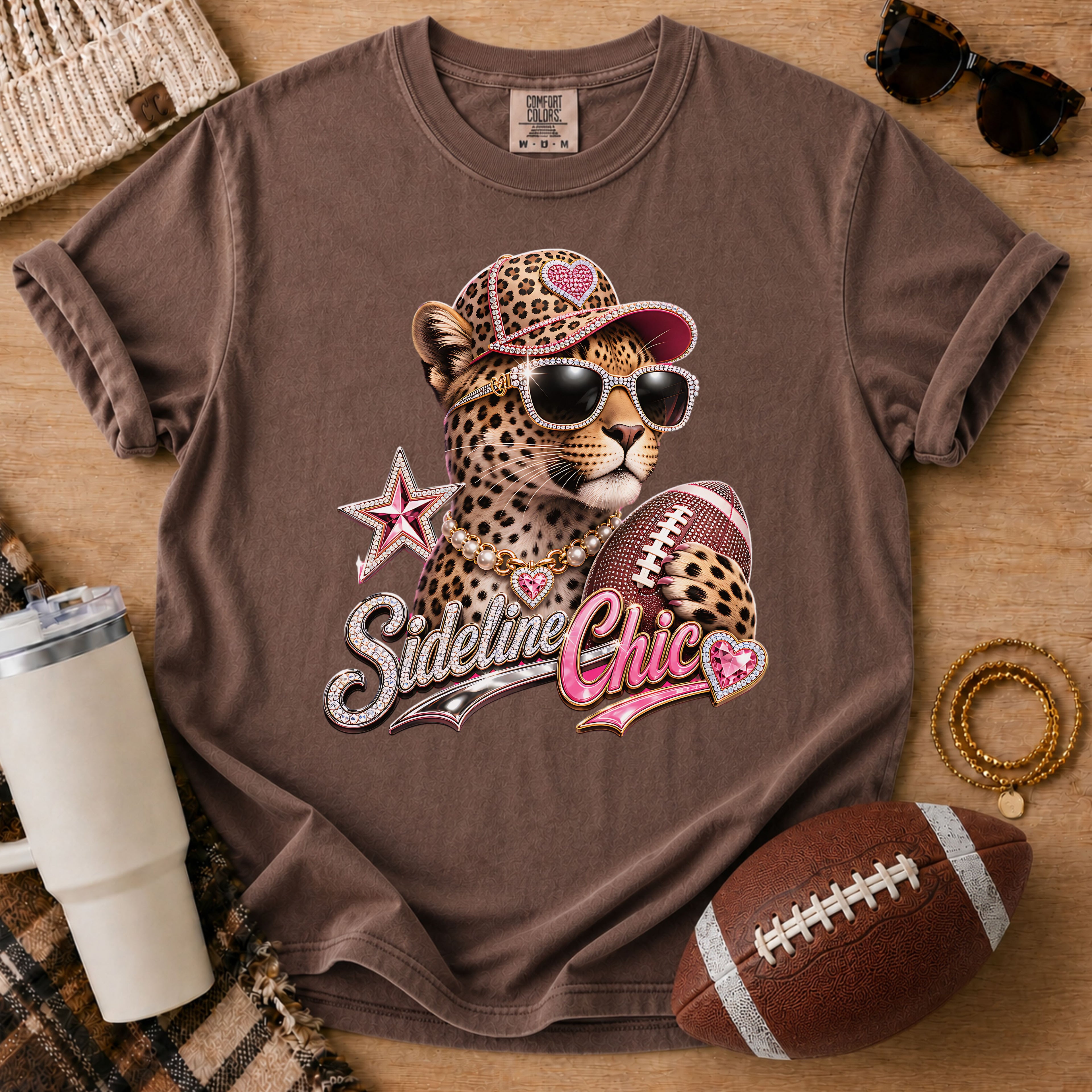 Dark brown football mom graphic tee, Comfort Colors Espresso, styled with game day accessories and a glam leopard holding a football.