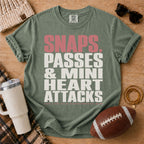 QB mom graphic T-shirt in olive green, Comfort Colors Moss, styled with football game day accessories and the bold quarterback mom slogan.