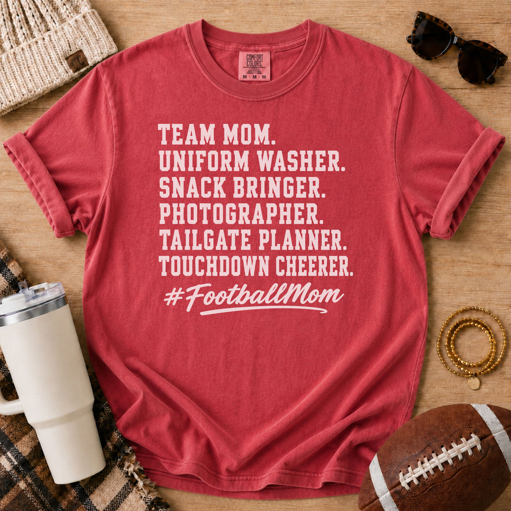 Super Football Mom football mom Comfort Colors tee in Crimson red, flat lay with a football and tumbler
