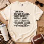 Super Football Mom football mom Comfort Colors tee in Ivory, flat lay with a football, tumbler, and sunglasses