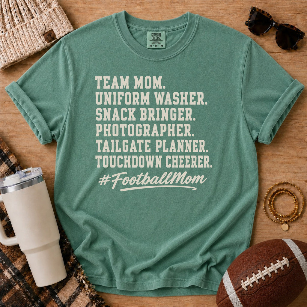 Super Football Mom football mom Comfort Colors tee in soft green, flat lay with a football and tumbler