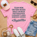 Team Mom Uniform Washer Snack Bringer baseball mom Comfort Colors Blossom tee flat lay with pink trucker hat, baseball purse, white sneakers, denim shorts, sunglasses, and jewelry.