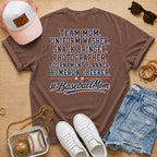 Team Mom Uniform Washer Snack Bringer baseball mom Comfort Colors Espresso tee flat lay with pink trucker hat, baseball purse, white sneakers, denim shorts, sunglasses, and jewelry.
