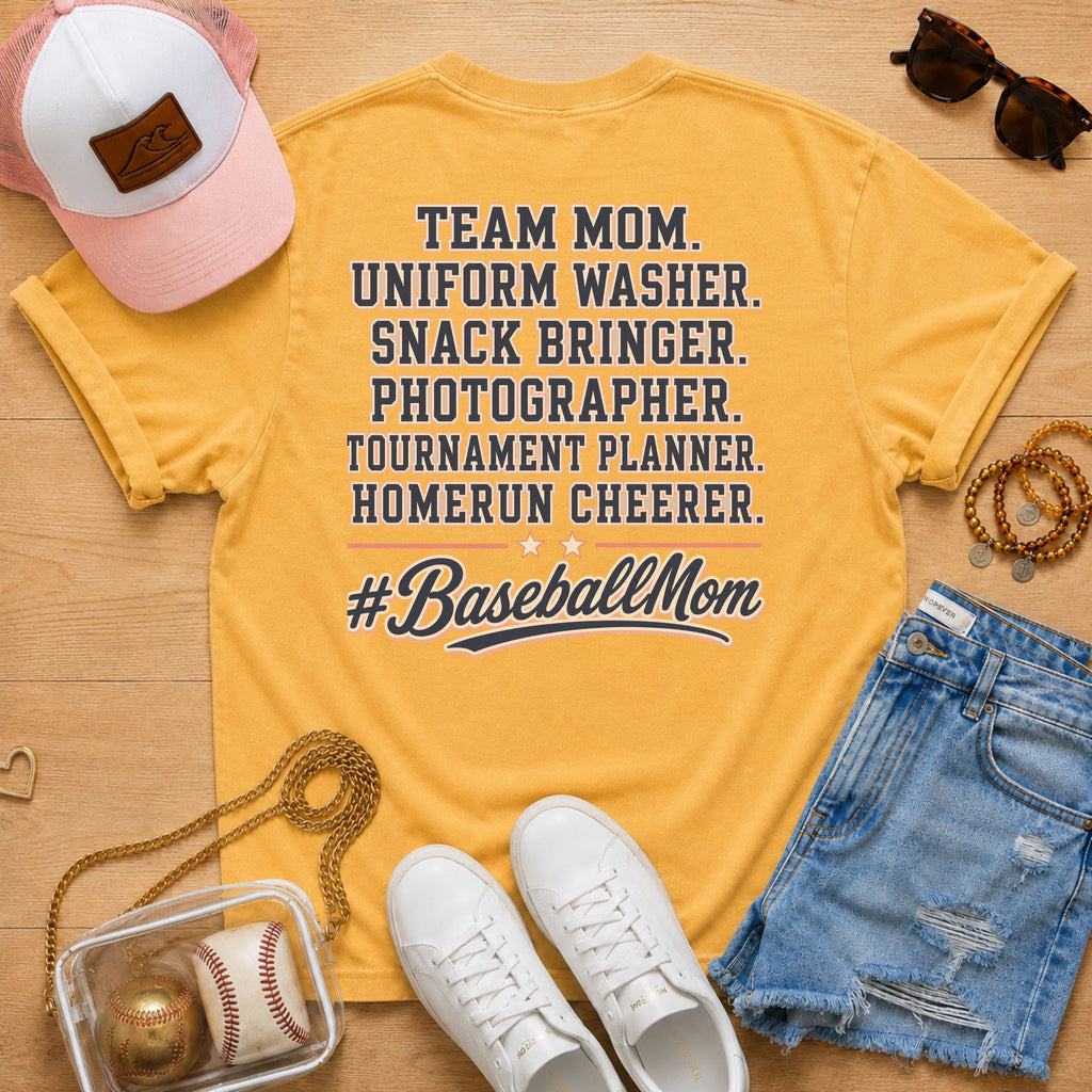 Team Mom Uniform Washer Snack Bringer baseball mom Comfort Colors Mustard tee flat lay with pink trucker hat, baseball purse, white sneakers, denim shorts, sunglasses, and jewelry.
