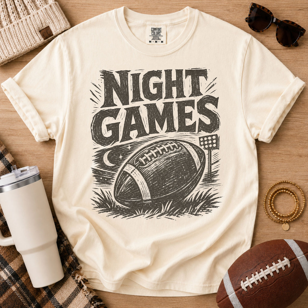 Cream football game day graphic tee, Comfort Colors Ivory, styled with a football and distressed vintage “Night Games” illustration.