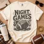 Cream football game day graphic tee, Comfort Colors Ivory, styled with a football and distressed vintage “Night Games” illustration.