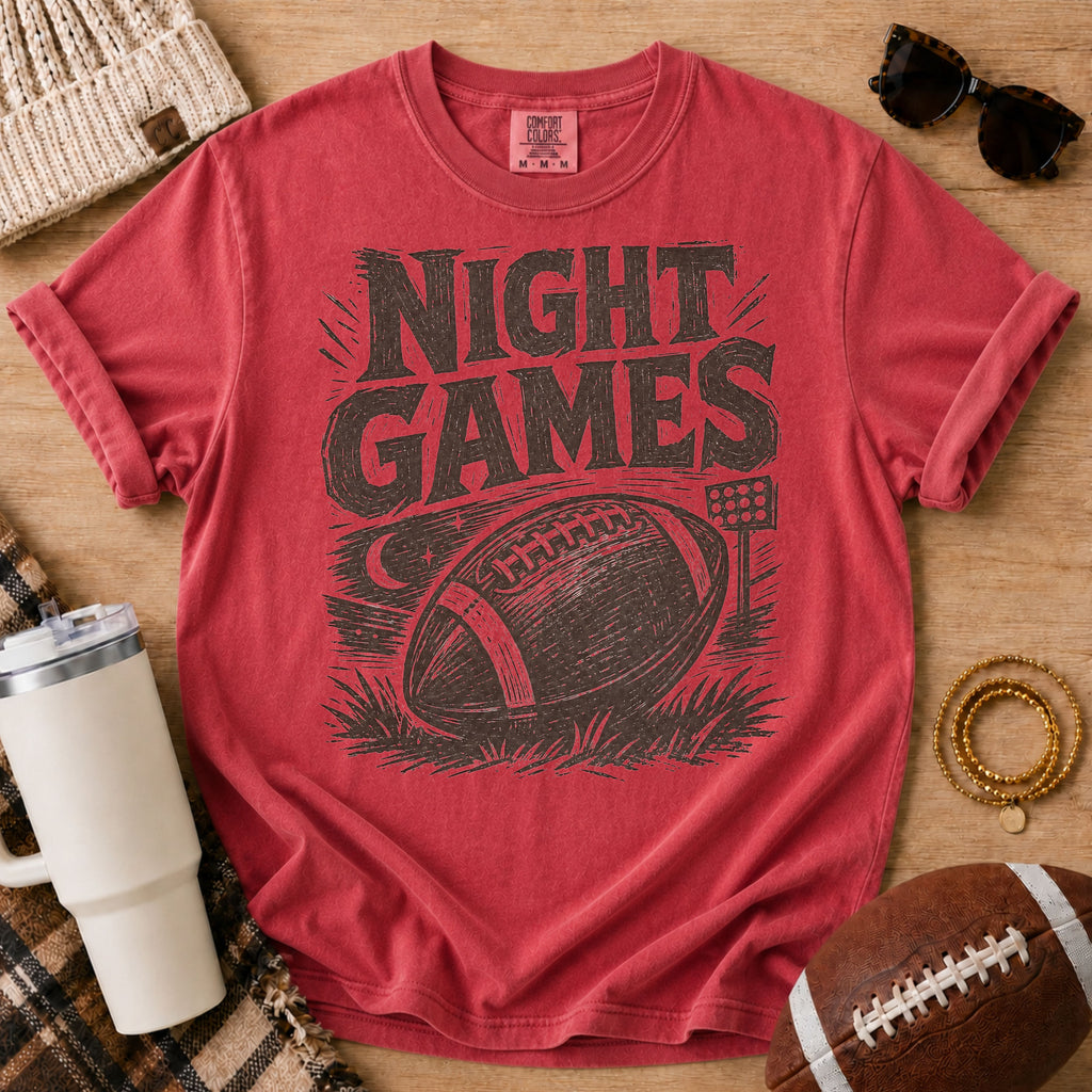 Vintage football game day T-shirt in deep red, Comfort Colors Crimson, featuring distressed “Night Games” lettering, a football and stadium lights.