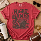 Vintage football game day T-shirt in deep red, Comfort Colors Crimson, featuring distressed “Night Games” lettering, a football and stadium lights.