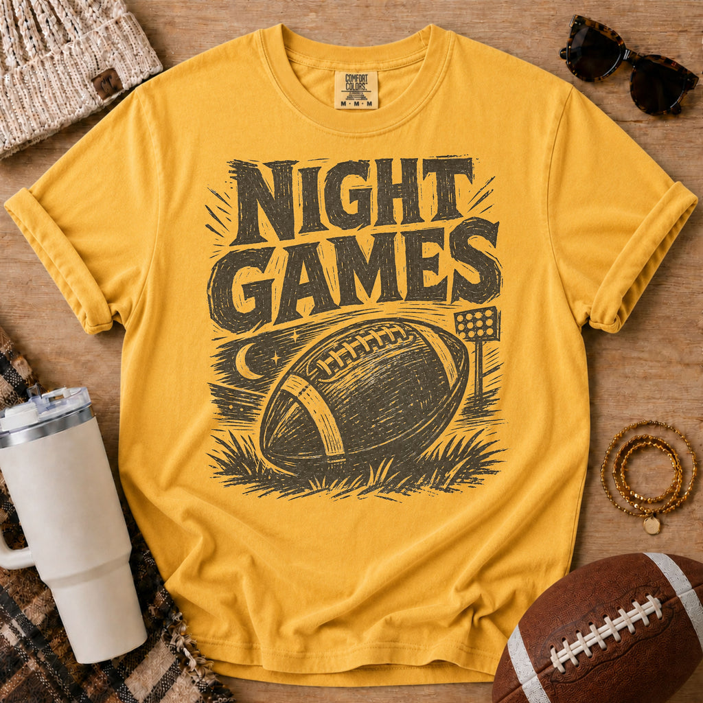 Golden yellow football graphic tee, Comfort Colors Mustard, styled with game day accessories and a distressed “Night Games” football design.